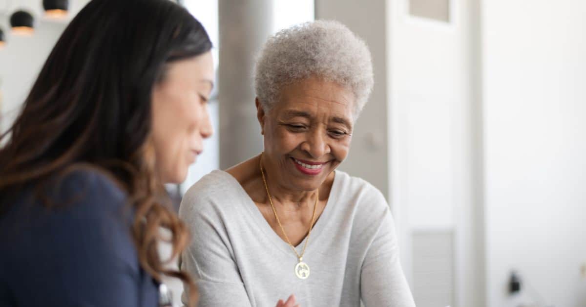 An older woman receiving tech assistance