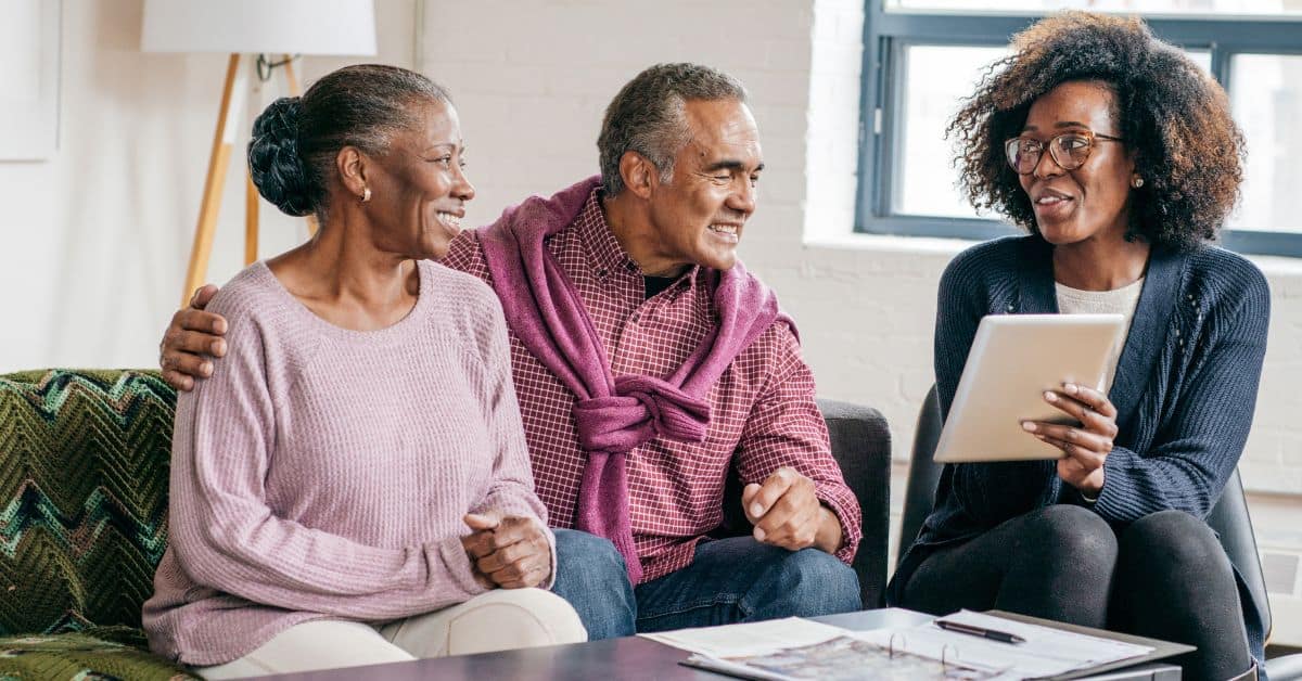 A family gathering on a couch receiving technical assistance for medicaid planning