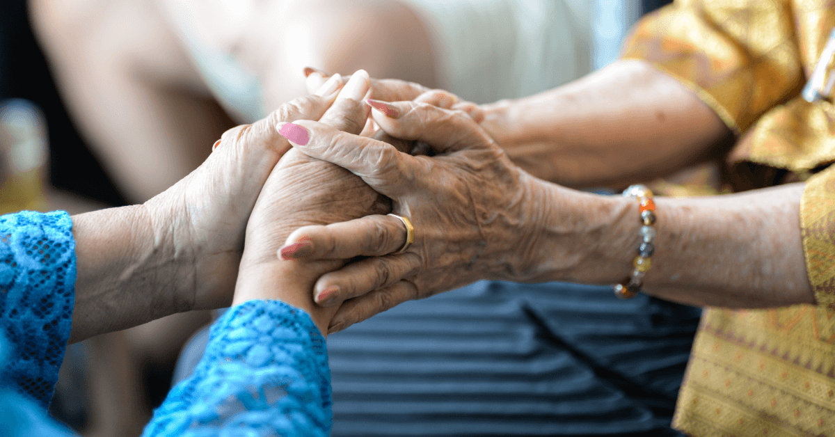 Two older women holding hands in a time of need for medicaid planning